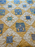 Quilt with blue and yellow houses and stars 